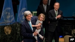 United Nations Secretary-General Ban Ki-moon, left, claps after U.S. Secretary of State John Kerry signs the Paris Agreement on climate change with his granddaughter Isabelle Dobbs Higginson, Friday, April 22, 2016 at U.N. headquarters. (AP Photo/Mary Altaffer)