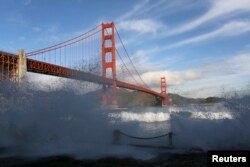 FILE - Waves crash against a sea wall in San Francisco Bay beneath the Golden Gate Bridge in San Francisco, California, Dec. 16, 2014.