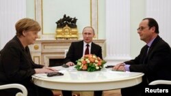 La canciller alemana, Angela Merkell, junto al presidente ruso, Vladimir Putin, y el mandatario francés, François Hollande. 