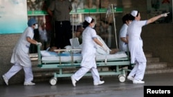 Medical personnel transport a victim of a factory explosion at a hospital in Kunshan, Jiangsu province, August 2, 2014. 