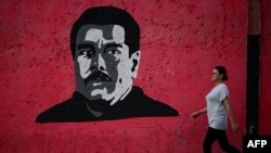 Una mujer camina frente a un mural del presidente venezolano Nicolás Maduro en Caracas, el 7 de enero de 2025.