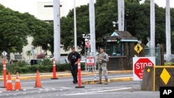 Personal de seguridad monta guardia frente a la entrada de la Base Conjunta de Pearl Harbor-Hickman en Hawái.