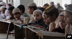FILE - Pakistani children attend lessons at a madrassa, or a religious school, to learn Quran, in Karachi, Pakistan, Sept. 2, 2015.