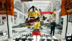 中共官媒新华社发布照片显示，浙江省湖州三一重工集团装载机生产基地的技术人员在检查生产线。（2024年3月27日）