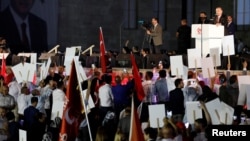 FILE - Turkey's President Recep Tayyip Erdogan addresses his supporters during a ceremony marking the first anniversary of the attempted coup in front of the Turkish Parliament in Ankara, July 16, 2017.