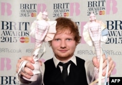 British singer-songwriter Ed Sheeran poses with his British album of the year award for 'X' and his British male solo artist award at the BRIT Awards 2015 in London on Feb. 25, 2015.