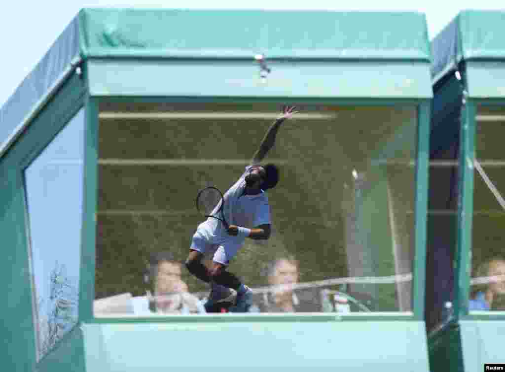 Latvia&#39;s Ernests Gulbis reflected in the window of aTV commentary position during the first round match against Britain&#39;s Jay Clarke during the Wimbledon Tennis Championships in London.