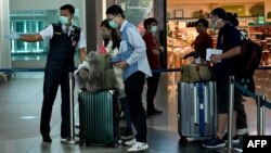 Chinese tourists wearing facemasks arrive Ngurah Rai airport in Denpasar on February 8, 2020. - The new coronavirus that emerged in a Chinese market at the end of last year has killed more than 700 people and spread around the world. (Photo by SONNY TUMBELAKA / AFP)