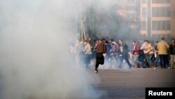 Những người biểu tình chống chính phủ và các thành viên Huynh đệ Hồi giáo bỏ chạy sau khi cảnh sát chống bạo động bắn hơi cay trong những cuộc đụng độ ở phố Ramsis, Cairo, 25/1/2014
