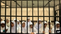 Egyptian women supporters of ousted President Mohamed Morsi stand inside the defendants' cage in a courtroom in Alexandria, Egypt, Nov. 27, 2013.