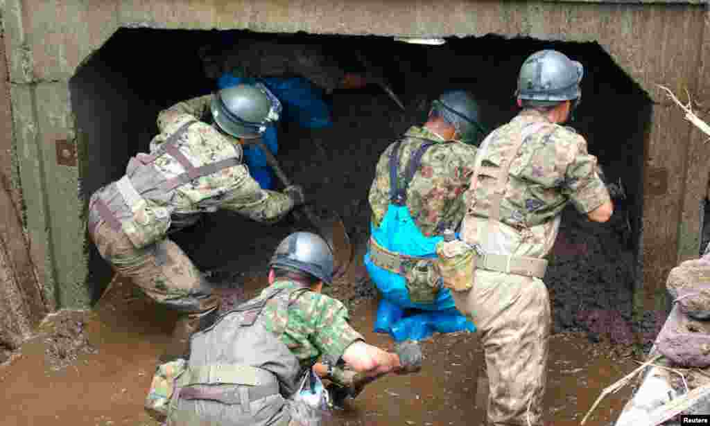 Japan Self-Defense Force soldiers search for missing people at an area devastated by heavy rains in Aso, Kumamoto prefecture, July 16, 2012. Japanese weather officials are warning of more torrential rain in northern and western Japan.