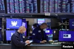 FILE - Traders work on the trading floor at the New York Stock Exchange (NYSE) in Manhattan, New York City, Dec. 28, 2021.