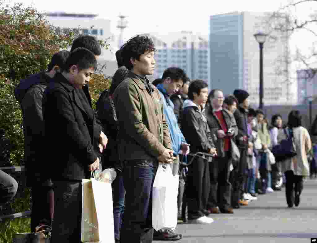 People take part in a moment of silence at 2:46 p.m. (0546 GMT) around the Imperial Palace in Tokyo, March 11, 2012. (Reuters)