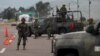 Soldiers stand guard at a checkpoint near Contepec, in Michoacan state, after Mexico's most notorious drug lord, Joaquin "El Chapo" Guzman, broke out of a high-security prison Saturday for the second time, escaping in a tunnel built right under his cell,