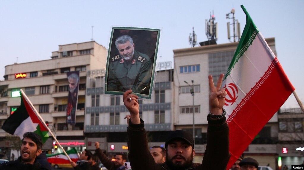 Un hombre iraní empuña un retrato del general Qassem Soleimani, mientras celebran el ataque con misiles iraníes a bases estadounidenses en Iraq, que no dejaron víctimas estadounidenses. Cortesía.