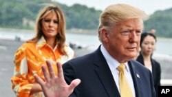 FILE - U.S. President Donald Trump, right, and First Lady Melania Trump arrive at the Japanese destroyer JS Kaga, in Yokosuka, south of Tokyo.