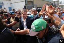 Venezuela's self-proclaimed president Juan Guaido greets supporters in Caracas, Venezuela, Tuesday, April 30, 2019.