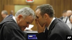 Oscar Pistorius talks with attorney Barry Roux, left, on the second day of trial, Pretoria, March 4, 2014.