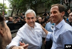 FILE - Chilean former President Sebastian Pinera (L) and Chilean right-wing lawyer and Santiago's mayoral candidate Felipe Alessandri greet supporters during Municipal elections in Santiago, Oct. 23, 2016.
