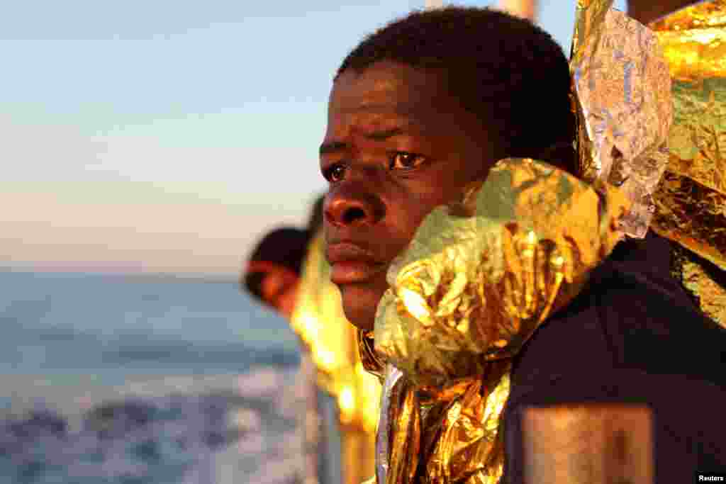 A migrant, covered with a thermal blanket, gazes at the sea aboard the former fishing trawler Golfo Azzurro of the Spanish NGO Proactiva Open Arms following a rescue operation near the coast of Libya in the central Mediterranean Sea.
