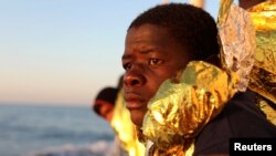 FILE - A migrant, covered with a thermal blanket, gazes at the sea aboard the former fishing trawler Golfo Azzurro of the Spanish NGO Proactiva Open Arms following a rescue operation near the coasts of Libya in the central Mediterranean Sea, Feb. 3, 2017. 
