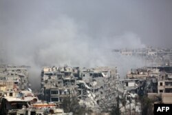 Smoke billows following Syrian government bombardment on the rebel-held besieged town of Harasta, in the Eastern Ghouta region on the outskirts of Damascus, March 12, 2018.
