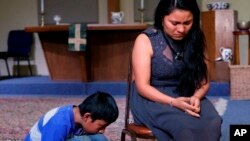 Hilda Ramírez, una inmigrante que vive ilegalmente en los Estados Unidos, y su hijo Ivan hablan con un periodista en la Iglesia Presbiteriana de San Andrés, en Austin, Texas. Hilda e Ian, de Guatemala, se han refugiado en la iglesia por más de un año.