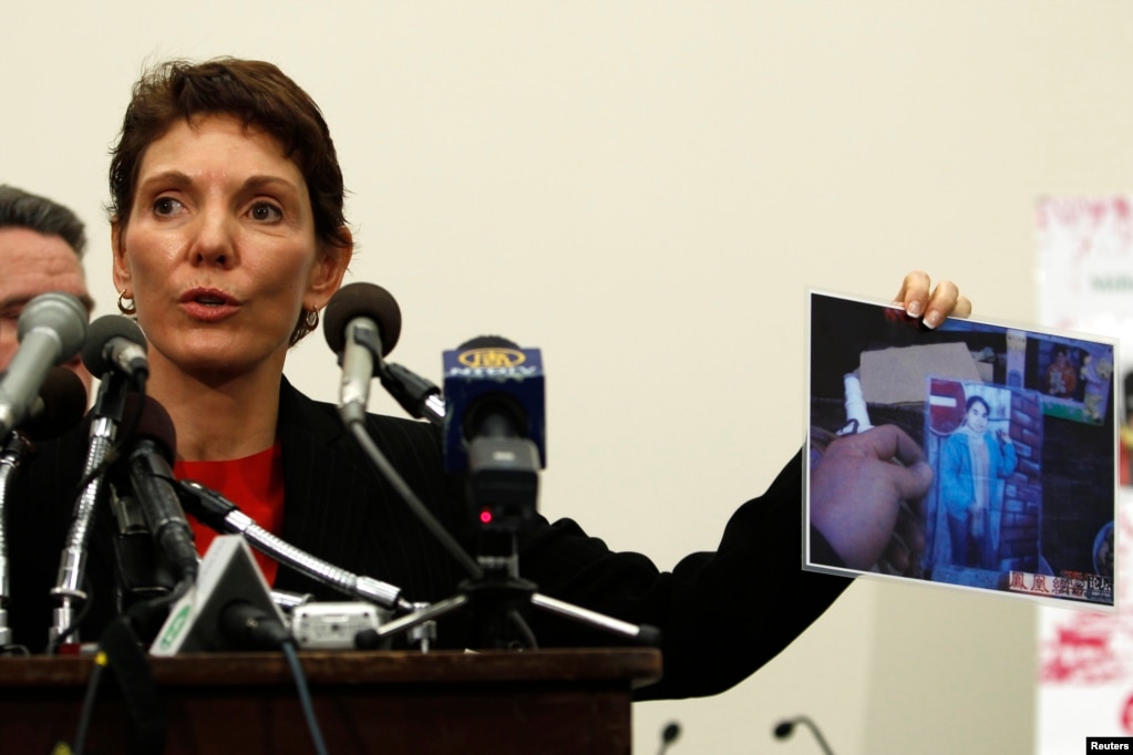 资料照：美国女性权益组织“女权无疆界”主席瑞洁女士 （Reggie Littlejohn）在美国会的一个听证会上展示被指中国强制堕胎的照片。（2011年1月18日）(photo:VOA)