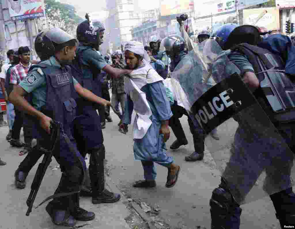 Police try to detain an activist of Hifazat-e-Islam during a clash in front of the national mosque in Dhaka, May 5, 2013. 