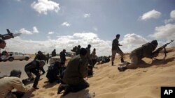 利比亚反对派力量在同政府军交火时隐蔽