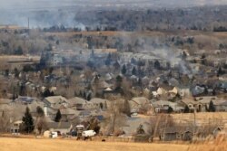Smoke rises a day after wind-driven wildfires prompted evacuation orders in Superior, Colorado, Dec. 31, 2021.