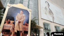 FILE - Portraits of Thailand's King Maha Vajiralongkorn Bodindradebayavarangkun and the late King Bhumibol Adulyadej are displayed at a department store in central Bangkok, Thailand, Jan. 17, 2017.