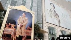 FILE - Portraits of Thailand's King Maha Vajiralongkorn Bodindradebayavarangkun and the late King Bhumibol Adulyadej are displayed at a department store in central Bangkok, Thailand.