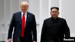 도널드 트럼프 미국 대통령과 김정은 북한 국무위원장이 지난해 6월 1차 정상회담이 열린 싱가포르 가펠라 호텔에서 오찬 후 함께 걷고 있다.