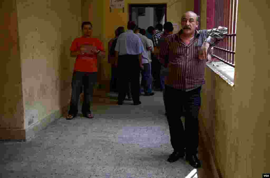 Men wait to vote at a polling station in central Cairo, Egypt, June 16, 2012. (Y. Weeks/VOA)