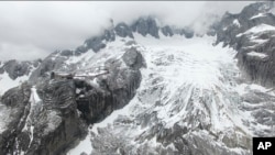 In this photo taken May 2018 and released by Yulong Snow Mountain Glacier and Environmental Observation Research Station on Oct. 18, 2018, the Baishui Glacier No.1 is visible next to a tourist viewing platform high in the Jade Dragon Snow Mountain in the 