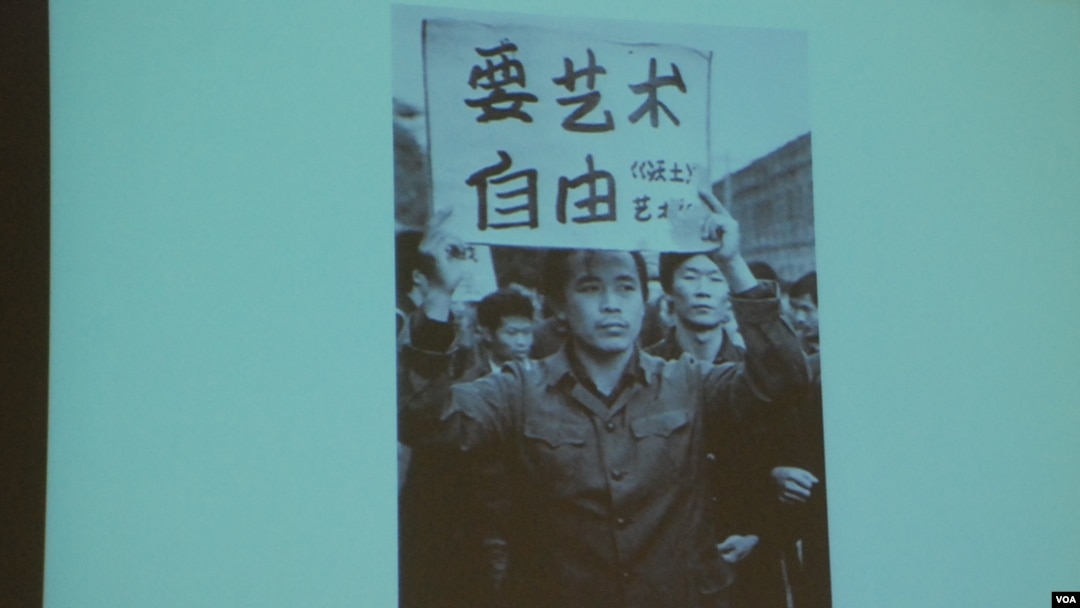 舒陽展示1979年10月北京藝術家參與遊行時高舉「要藝術要自由」的標語的照片