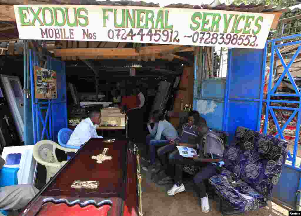 Bereaved relatives wait to pick newly built coffins from a roadside showroom in Nairobi, Kenya, May 20, 2013.