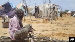 A Somali man from southern Somalia cuts tree branches to construct a makeshift shelter in refugee camp in Mogadishu, Somalia, August 11, 2011.