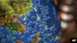 FILE - In this July 13, 2018, file photo, a globe shows the islands on the South China Sea with nine-dash line claims under Chinese territory on display at a bookstore in Beijing, China.