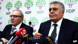 Turkey's Minister for EU Affairs Ali Haydar Konca, left, and Development Minister Muslum Dogan, members of the of the pro-Kurdish People's Democracy Party, or HDP, speak to the media in Ankara, Sept. 22, 2015.