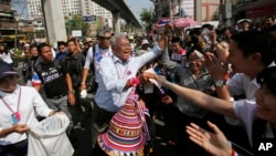Anti-government protest leader Suthep Thaugsuban collects donation from supporters during a march through Bangkok, Thailand, Feb. 3, 2014. 