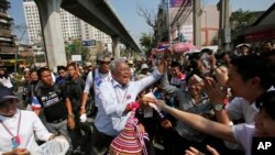 Anti-government protest leader Suthep Thaugsuban collects donation from supporters during a march through Bangkok, Thailand, Feb. 3, 2014. 