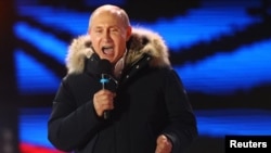 TT Nga Vladimir Putin đọc diễn văn trong một cuộc tuần hành và hòa nhạc đánh dấu kỷ niệm năm thứ Tư ngày sáp nhập bán đảo Crimé, tại quảng trường Manezhnaya ở trung tâm Moscow, Nga ngày 18/3/2018. REUTERS/David Mdzinarishvili - 