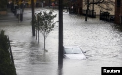 Floodwaters surround a car parked on a street in Hoboken, New Jersey, October 30, 2012, after Sandy, one of the biggest storms ever to hit the United States, roared ashore with fierce winds and heavy rain near Atlantic City.