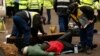 Police officers work to remove protesters who had chained themselves to a homemade coffin close to the entrance of the IGas exploratory gas drilling site at Barton Moss, near Manchester, northern England, March 6, 2014