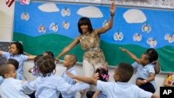 FILE - Former first lady Michelle Obama dances with students at a Washington school that was part of the Turnaround Arts Initiative, May 24, 2013