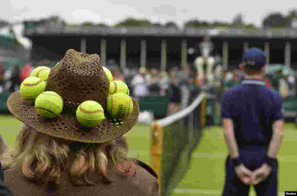 A spectator watches play on an outside court at the Wimbledon Tennis Championships, in London.