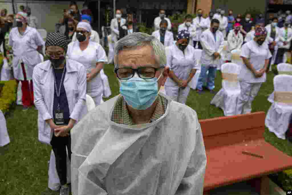 Health workers at the San Juan de Dios hospital observe a minute of silence in memory of their colleagues who have fallen victim to COVID-19, at the hospital in Guatemala City, Friday, Oct. 9, 2020. (AP Photo/Moises Castillo)