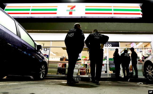 U.S. Immigration and Customs Enforcement agents serve an employment audit notice at a 7-Eleven convenience store, Jan. 10, 2018, in Los Angeles.